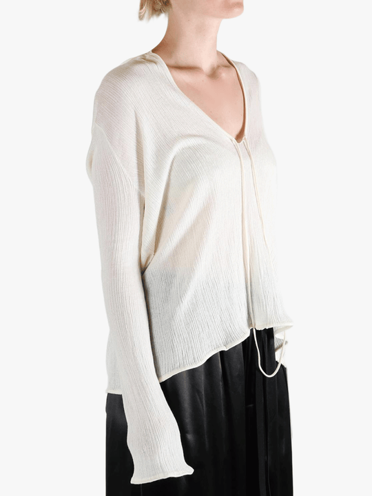 White sweater worn by a person, showing the sweater's fit
