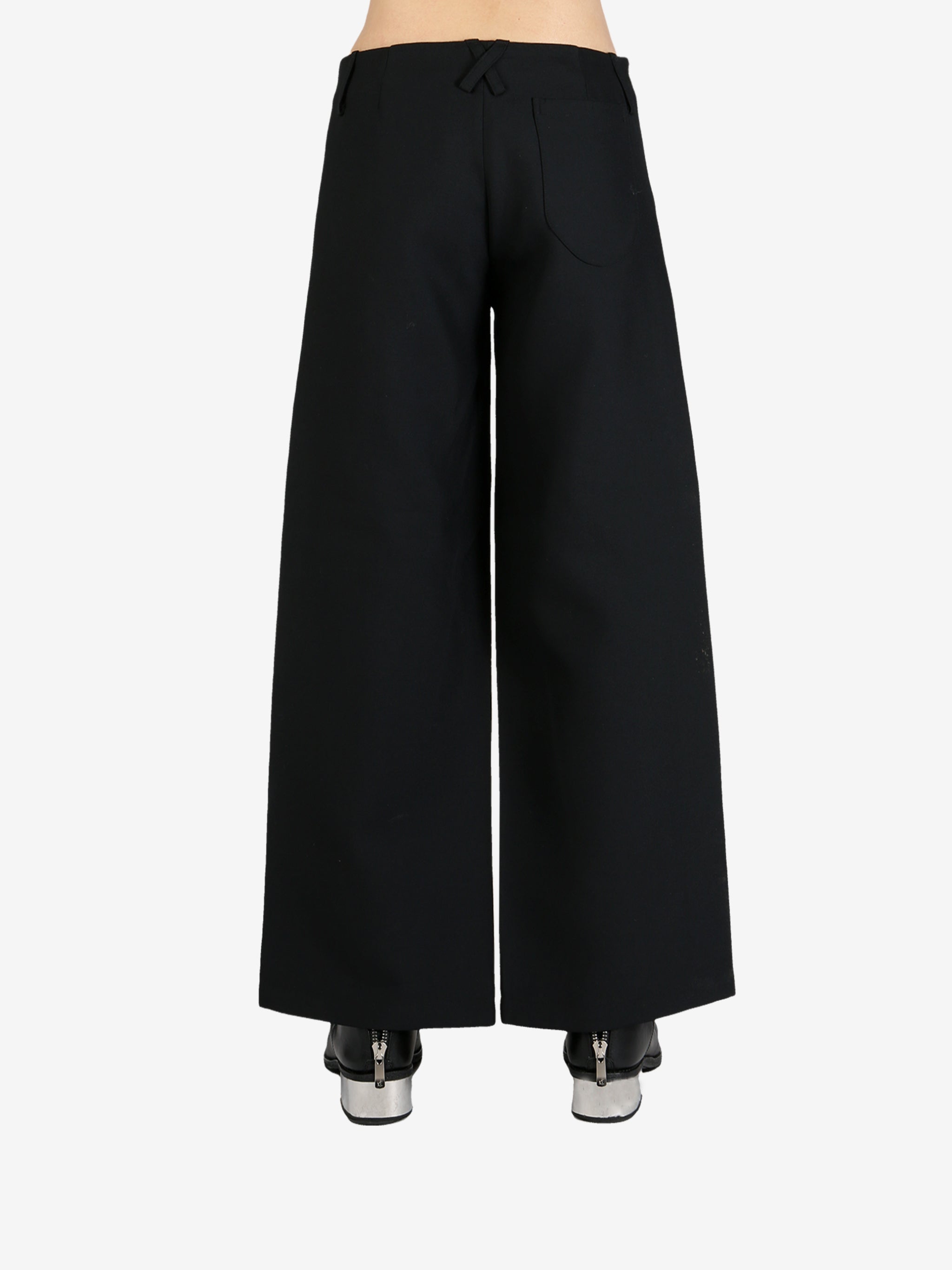 Black pants worn by a person, showing the pants's fit