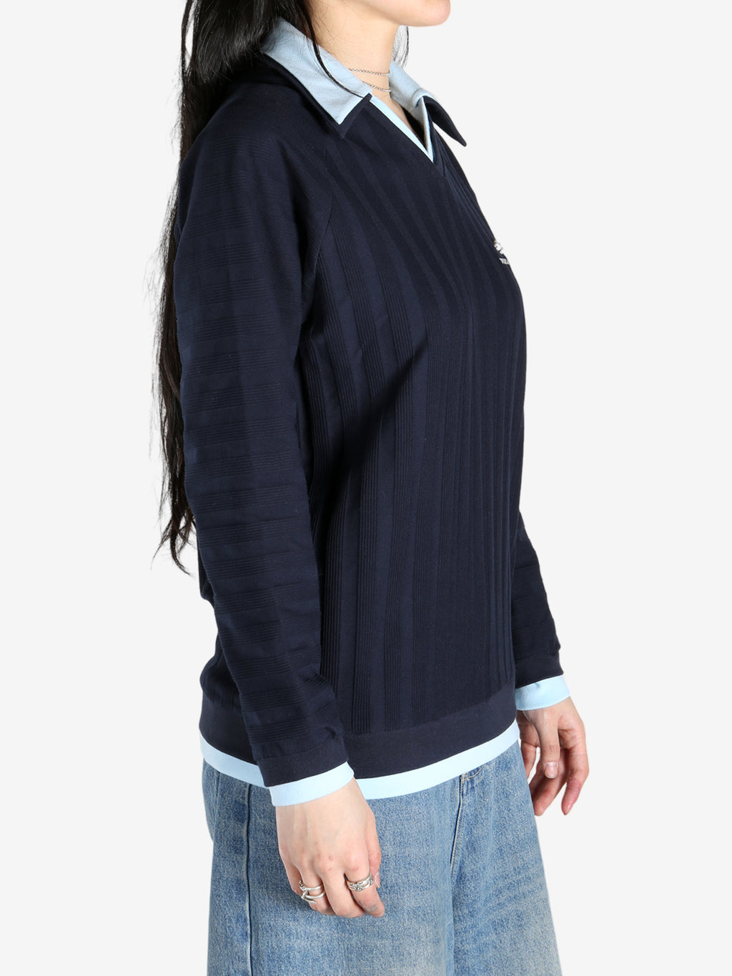 Blue knitwear worn by a person, showing the tops fit