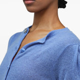 White jewelry worn by a person, showing the jewelry fit
