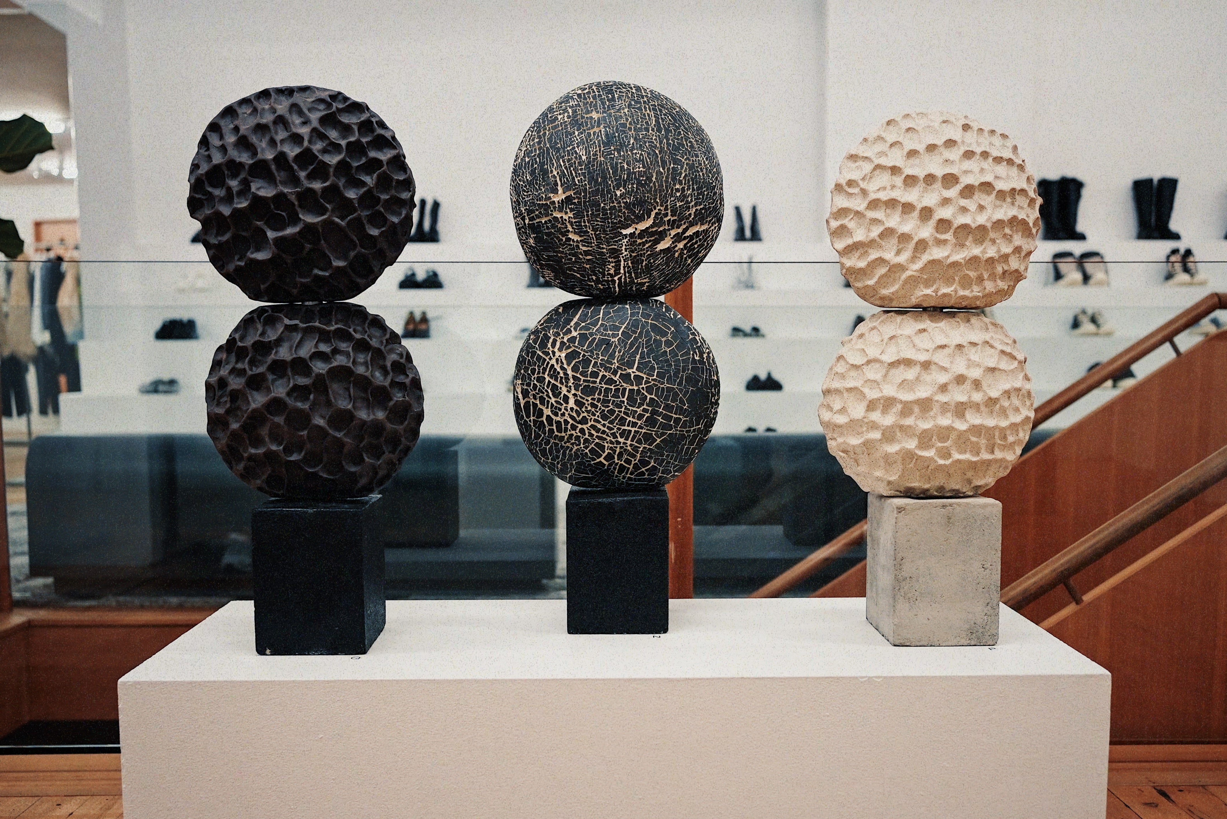 Three ceramic sculptures by Ann Shure in stoneware and porcelain on steel and concrete bases.