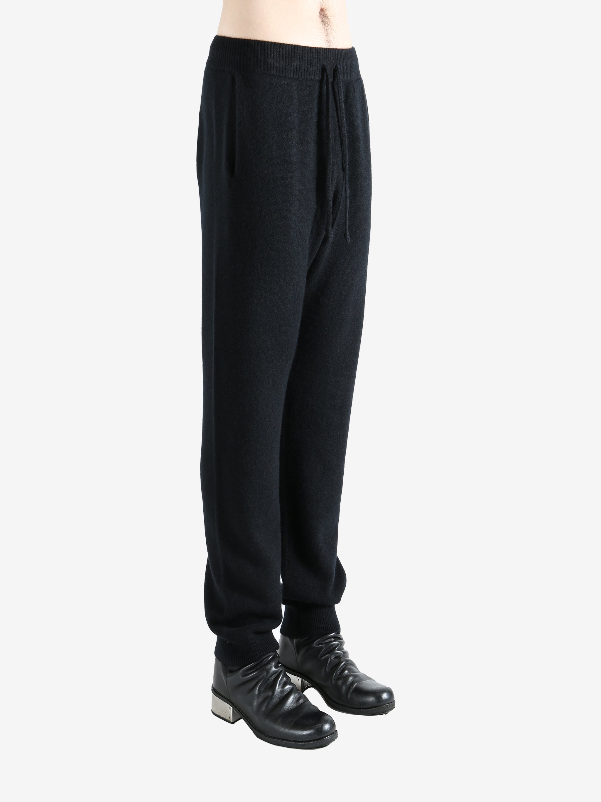 Black pants worn by a person, showing the pants' fit