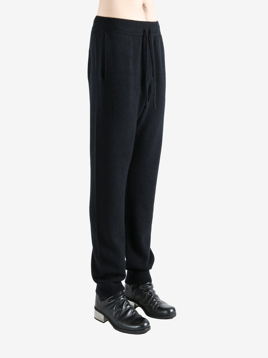 Black pants worn by a person, showing the pants' fit