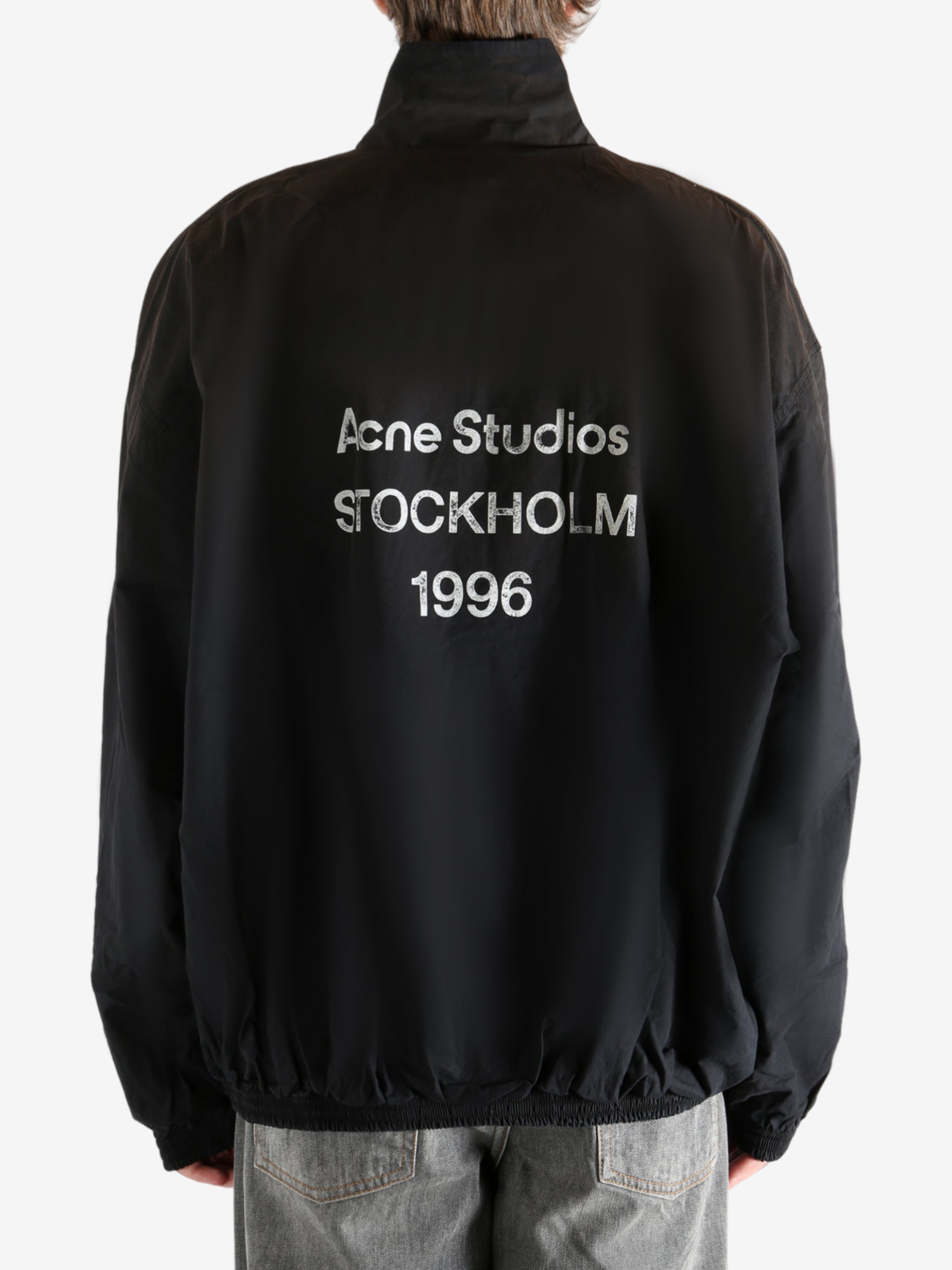 Black coat worn by a person, showing the coat's fit