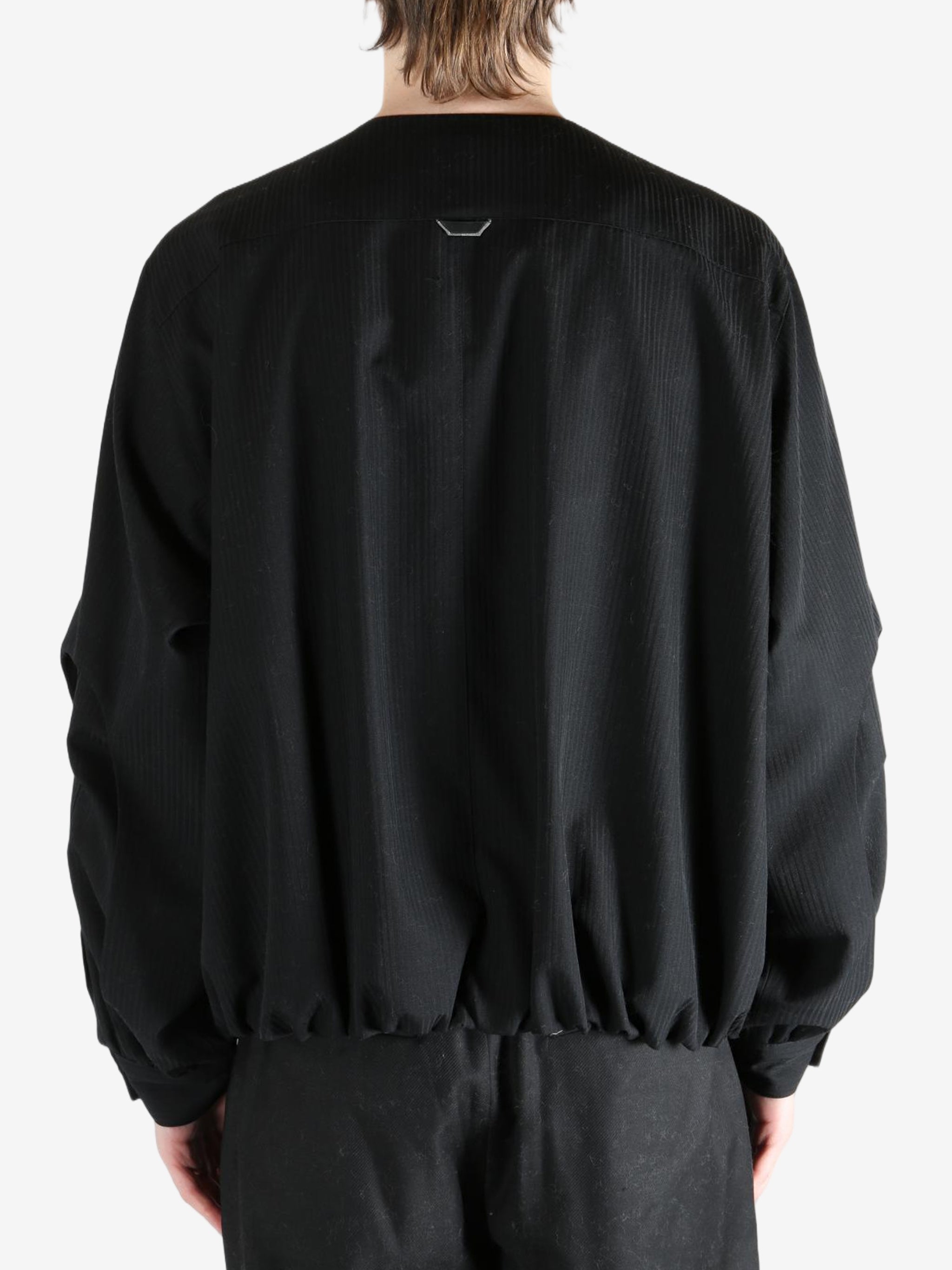 Black coats worn by a person, showing the coats fit