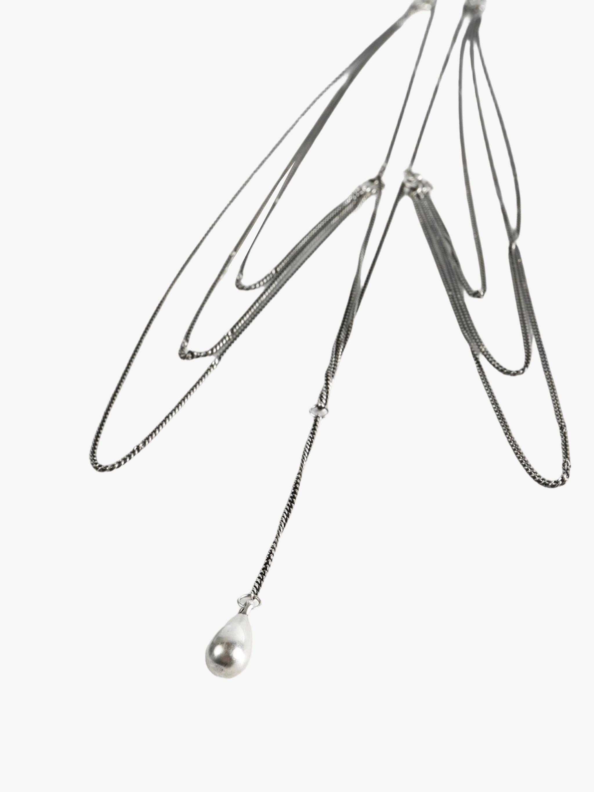 Close up of grey necklace, showing texture of the silver fabric