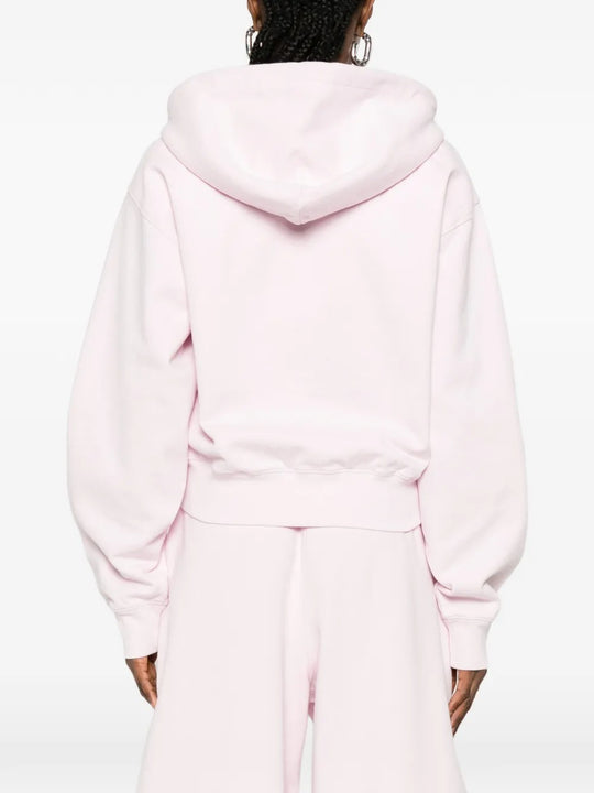 Pink hoodie worn by a person, showing the hoodie's fit