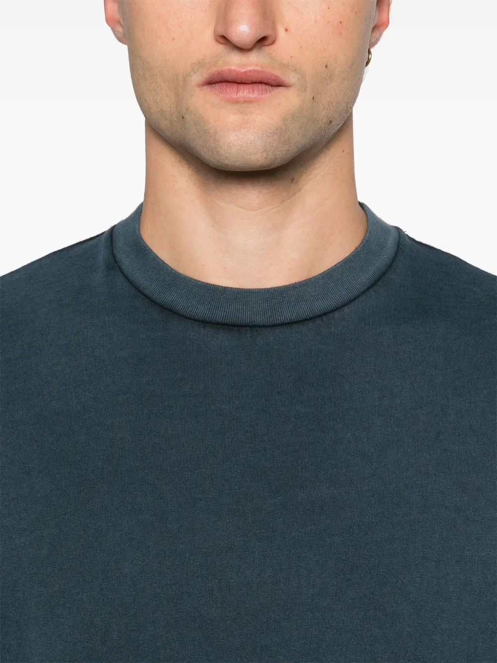 Close up of blue shirt worn by a person, showing the shirt's fit