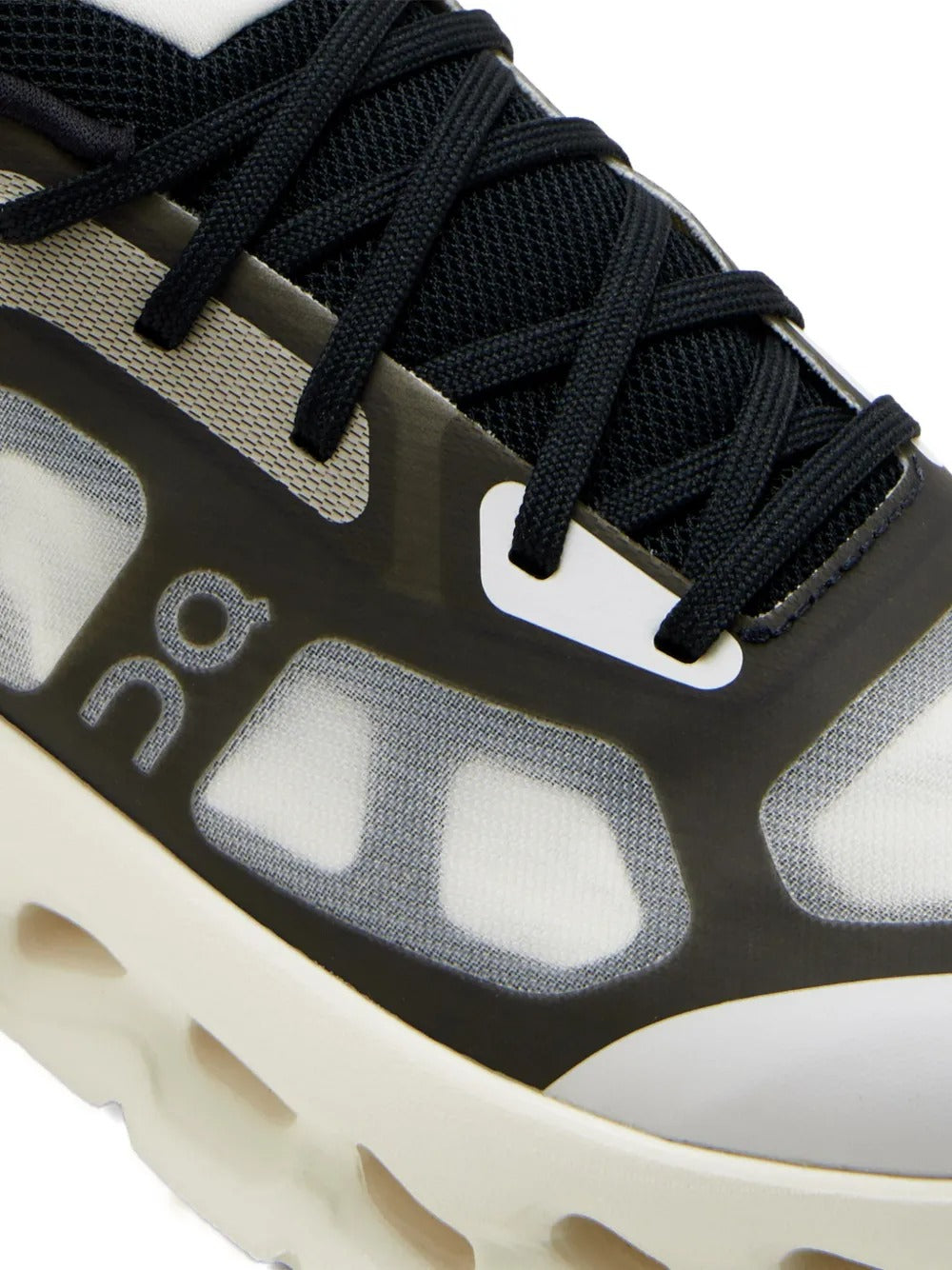 Close up of black sneakers, showing texture of the rubber and polyester fabric