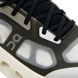 Close up of black sneakers, showing texture of the rubber and polyester fabric