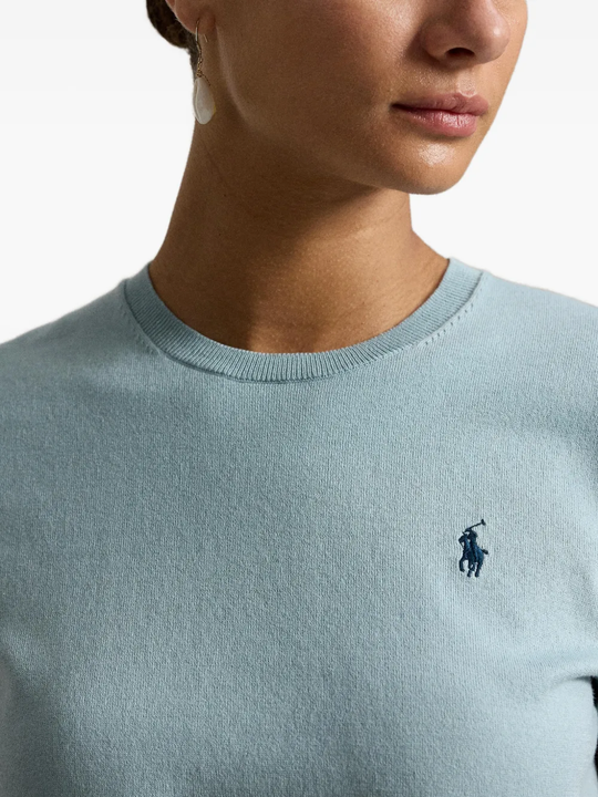 Green knitwear worn by a person, showing the knitwear fit