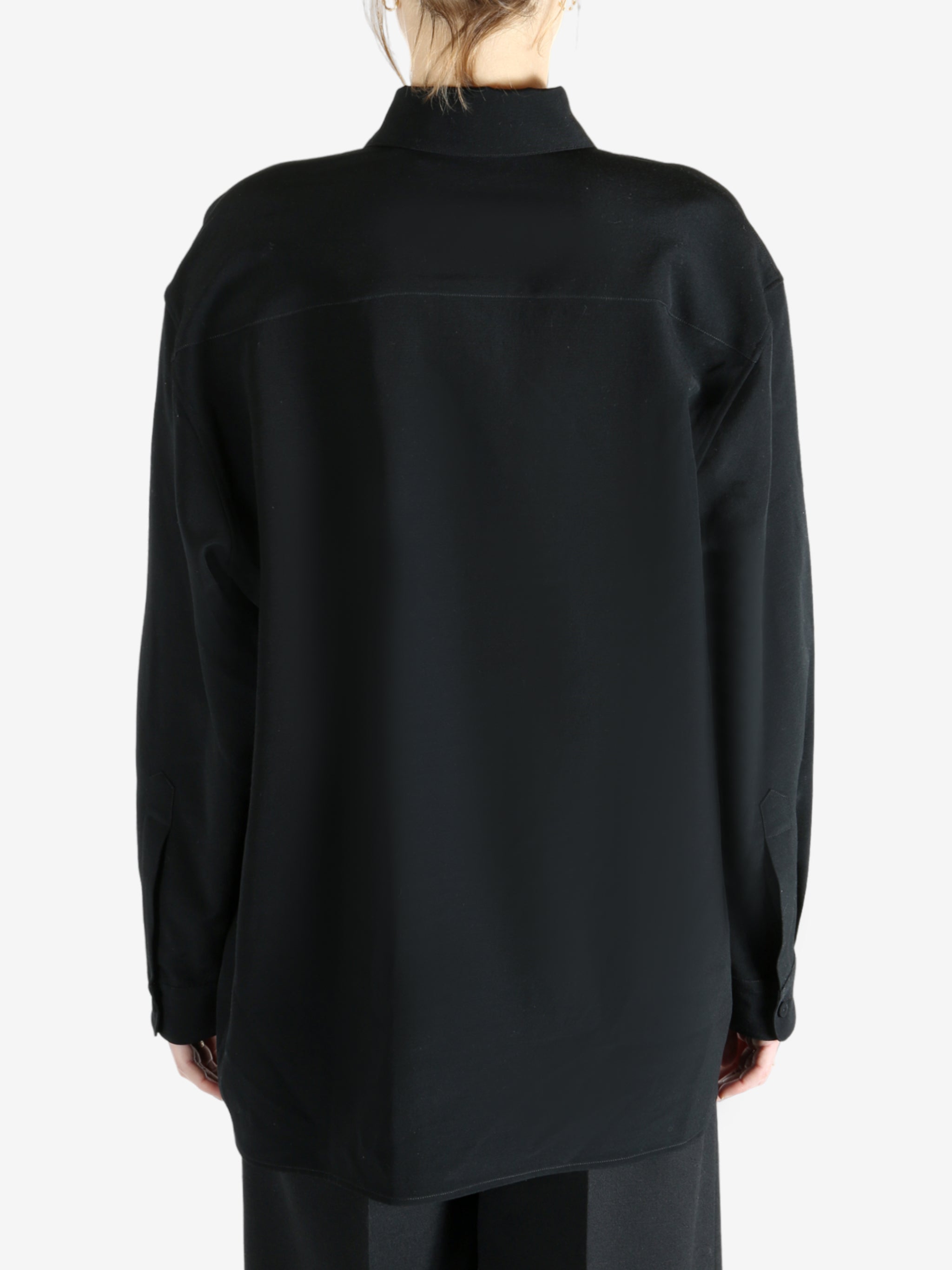 Black shirt worn by a person, showing the shirt's fit