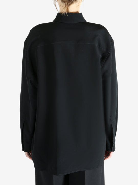 Black shirt worn by a person, showing the shirt's fit
