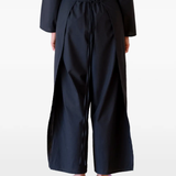 Black pants worn by a person, showing the pants's fit