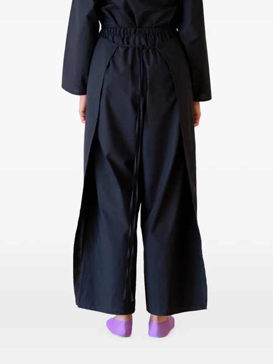 Black pants worn by a person, showing the pants's fit