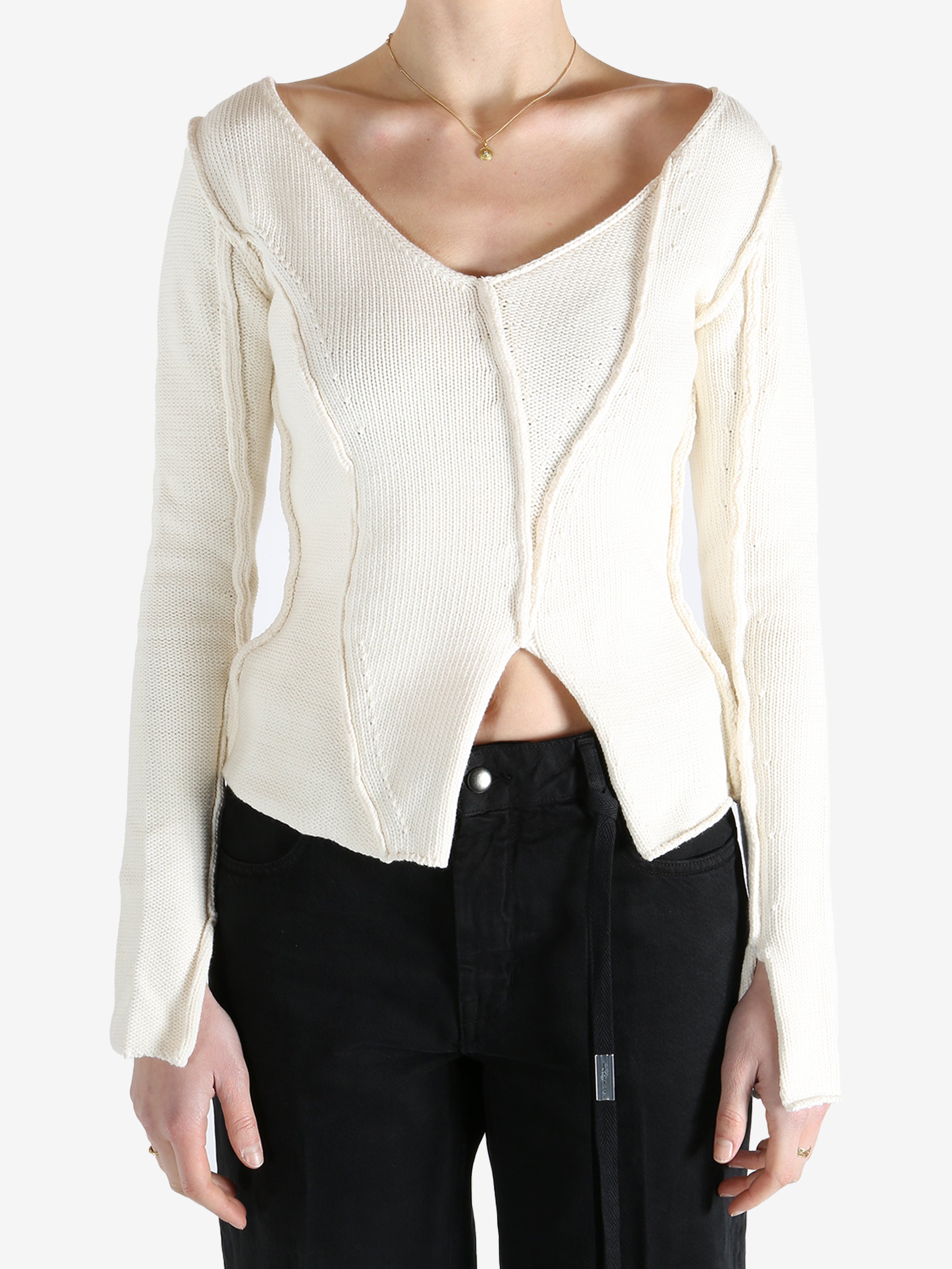 White sweater worn by a person, showing the sweater's fit