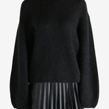 Black knitwear worn by a person, showing the knitwear fit