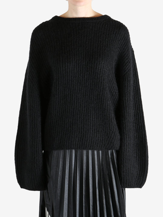 Black knitwear worn by a person, showing the knitwear fit