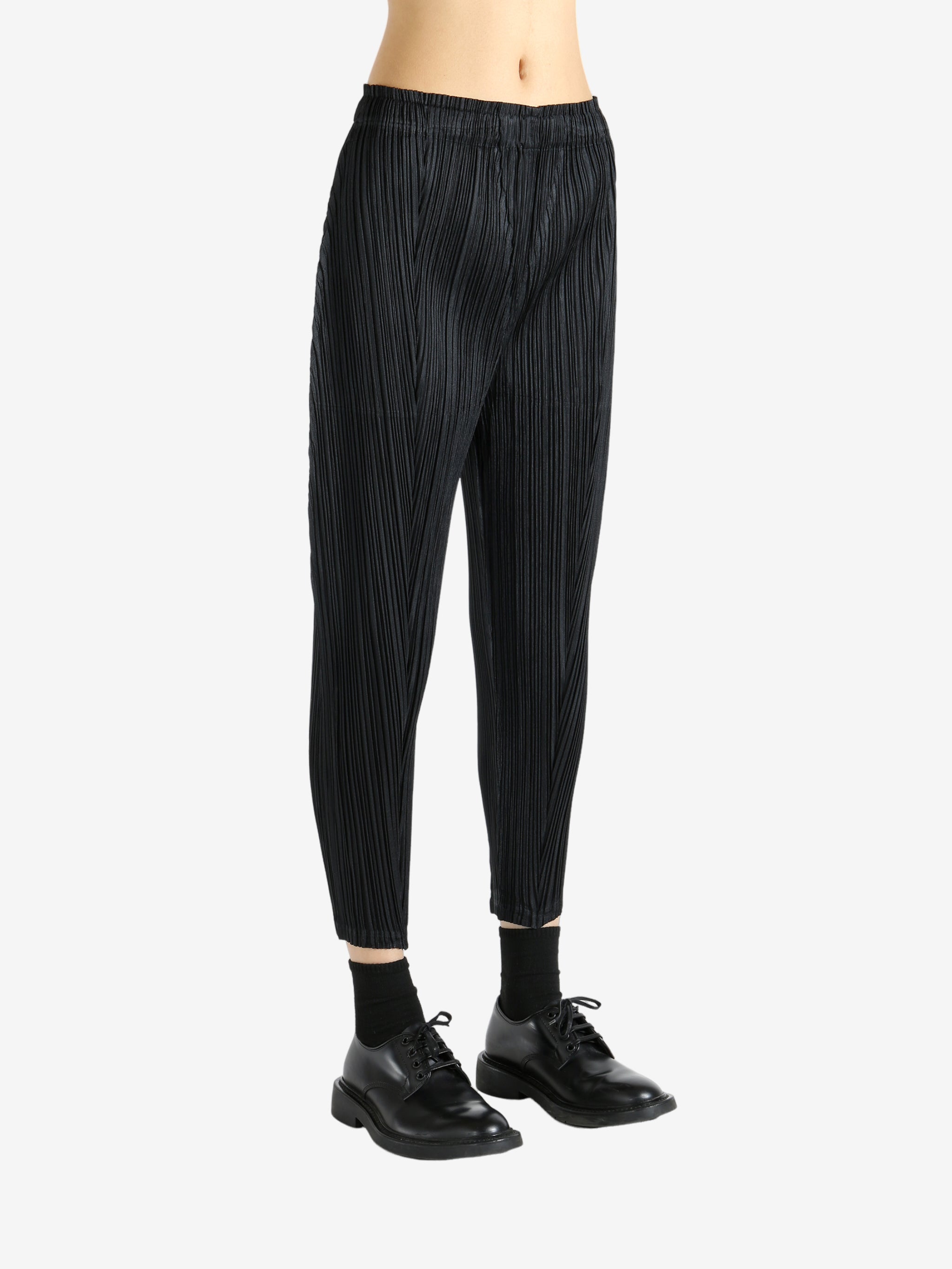 Black pants worn by a person, showing the pants' fit