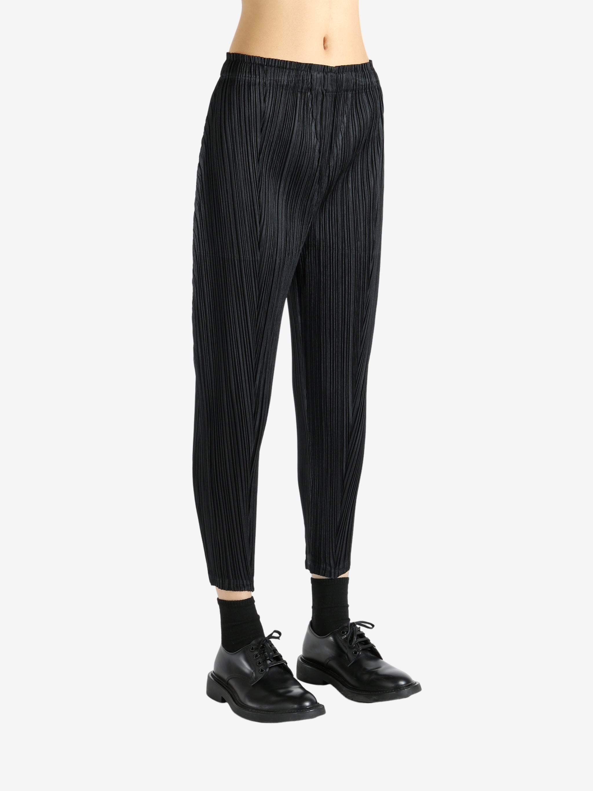 Black pants worn by a person, showing the pants' fit