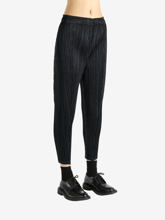 Black pants worn by a person, showing the pants' fit