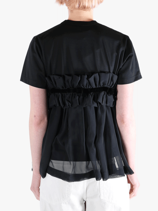 Black t-shirts worn by a person, showing the t-shirts fit