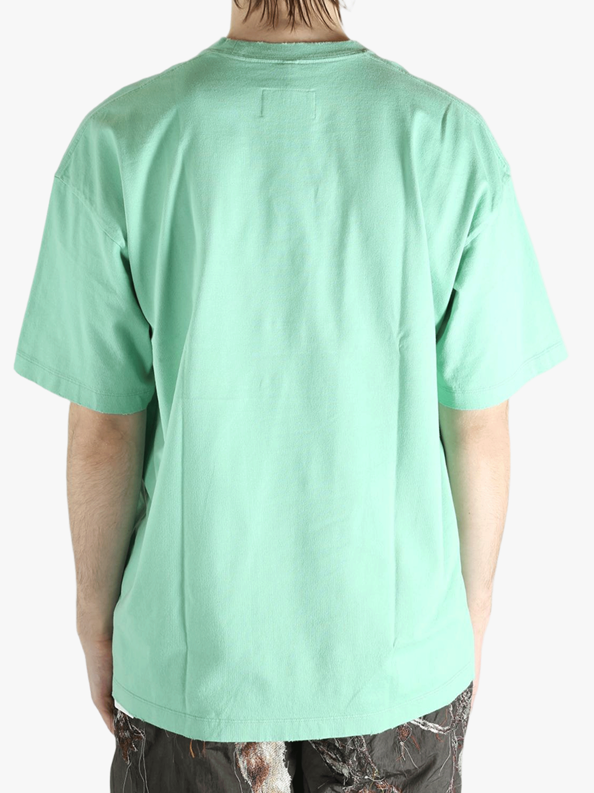 Green t-shirt worn by a person, showing the t-shirt's fit