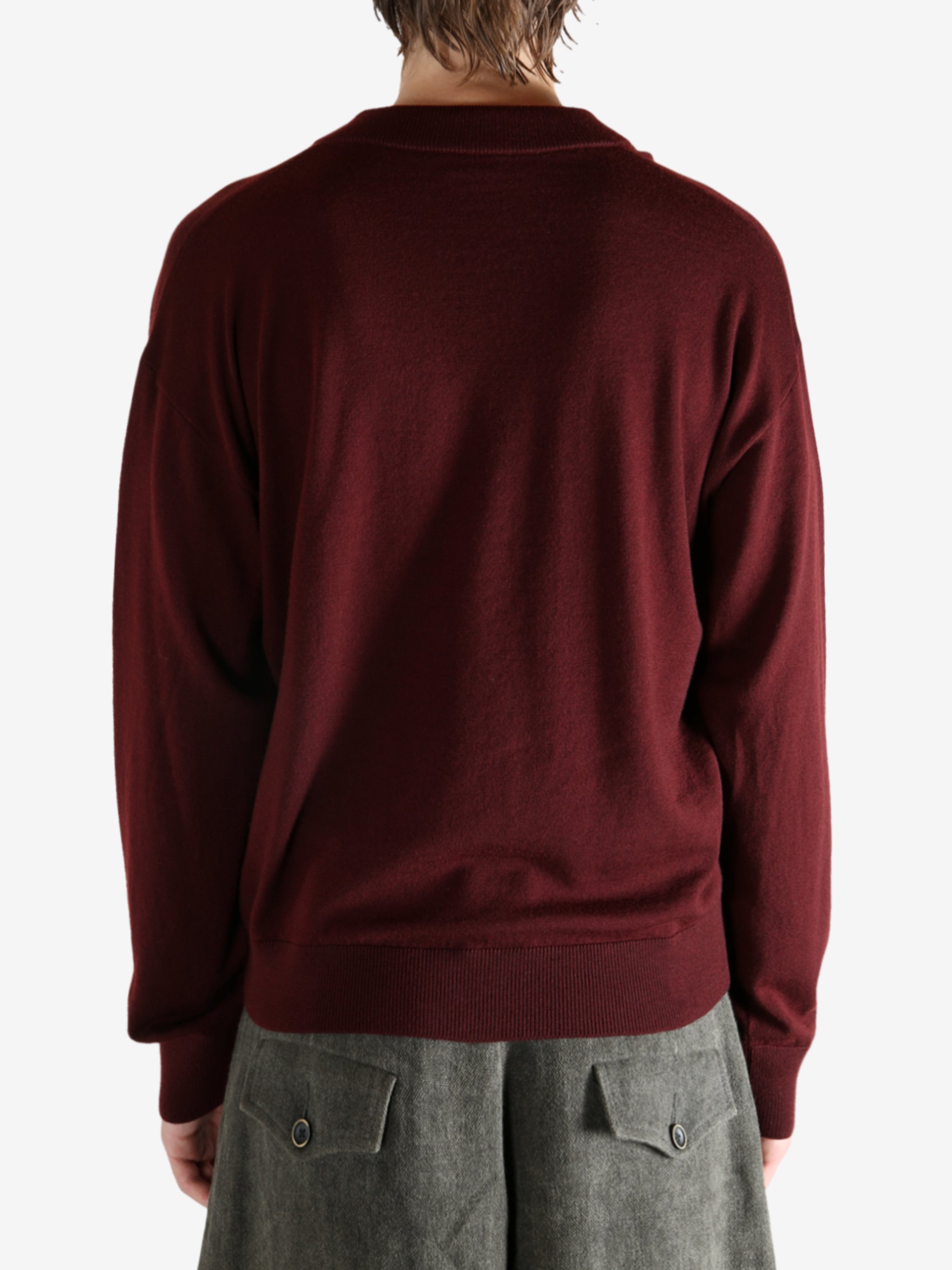 Red sweater worn by a person, showing the sweater's fit