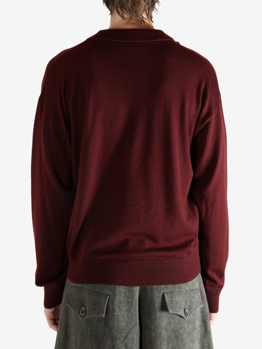 Red sweater worn by a person, showing the sweater's fit