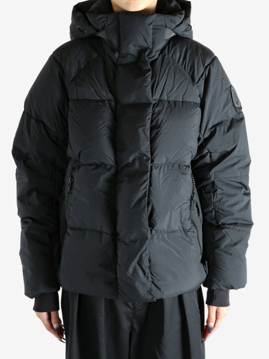 Black coat worn by a person, showing the coat's fit