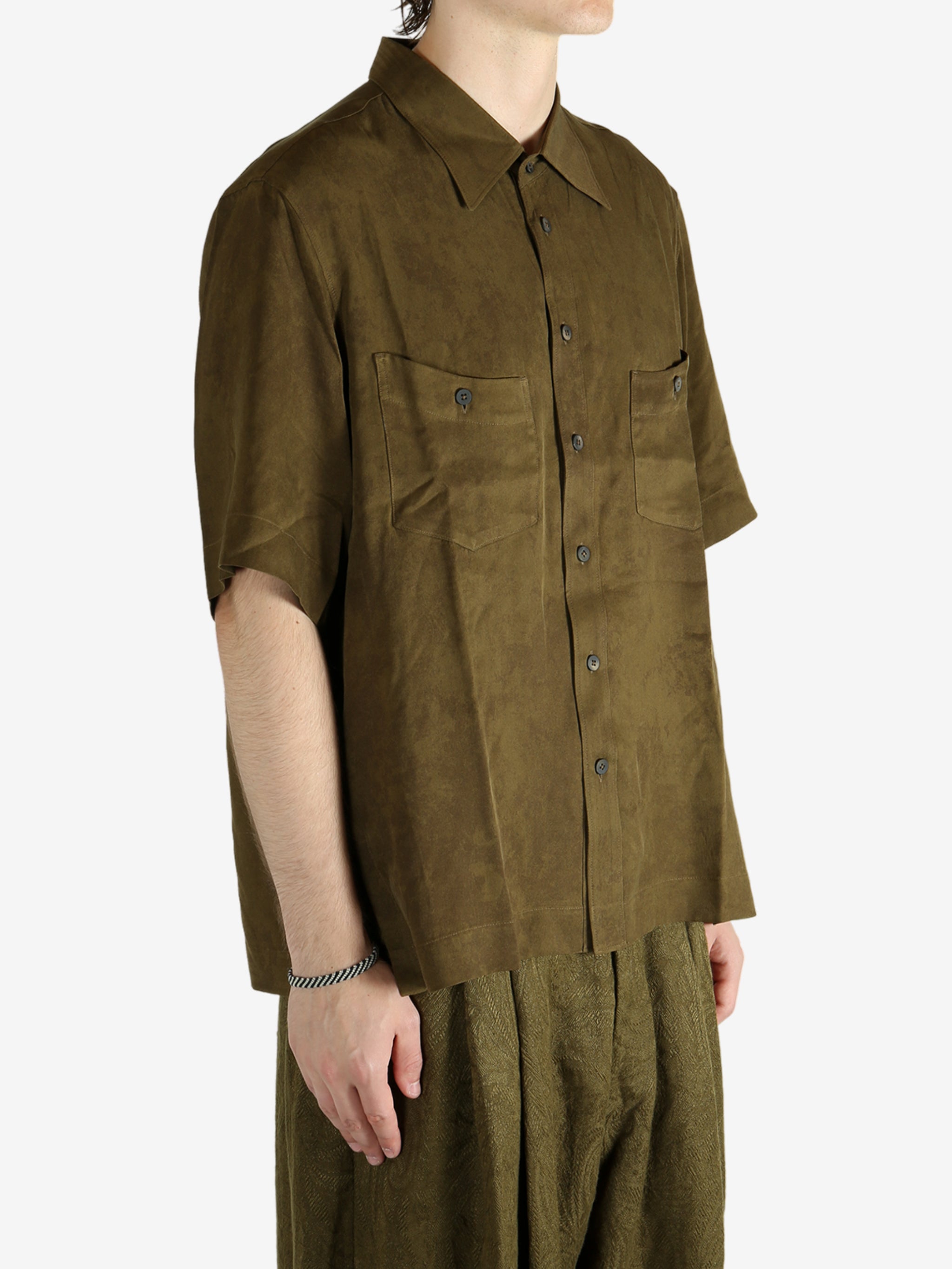 Green shirt worn by a person, showing the shirt's fit