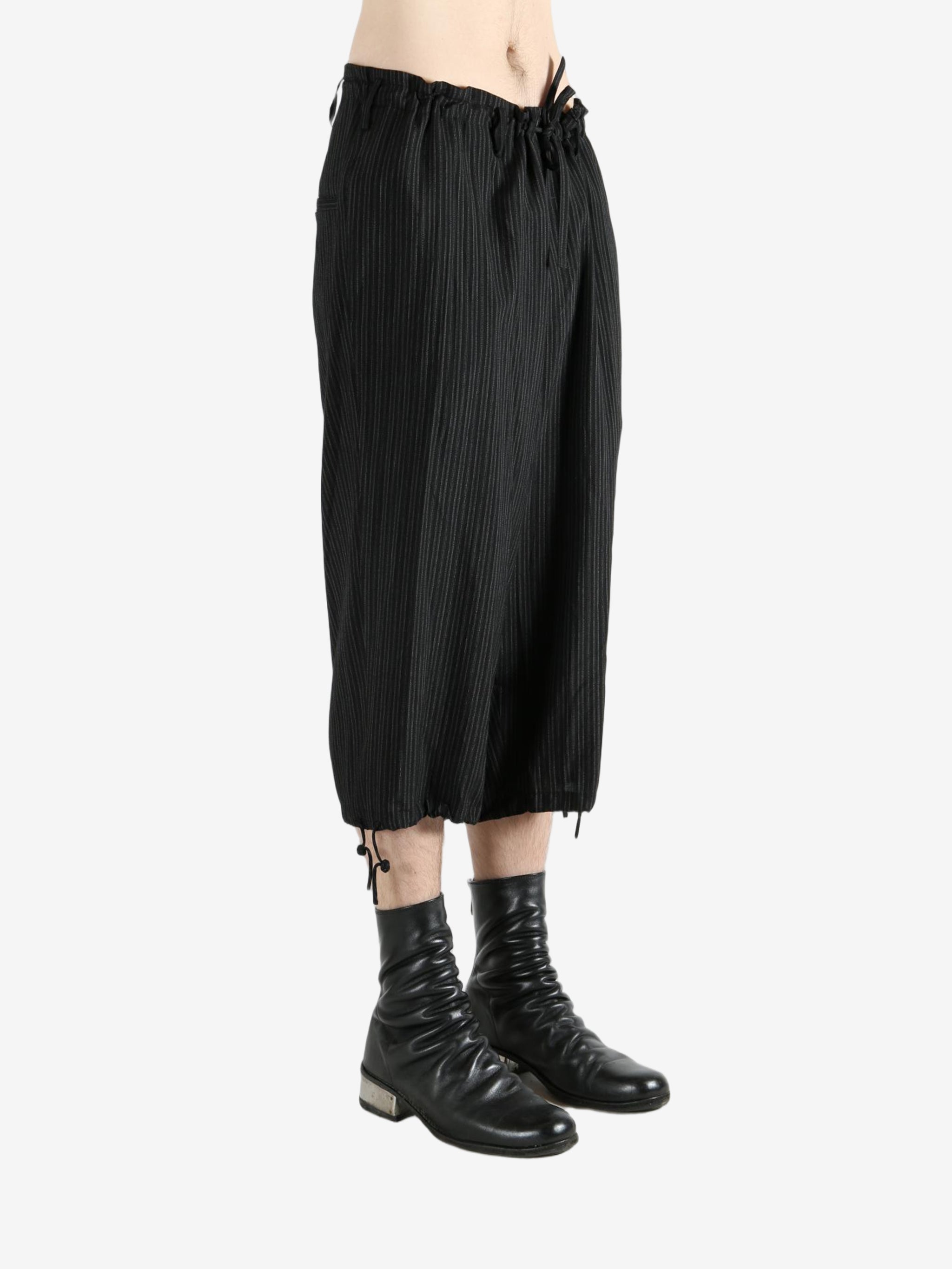 Black pants worn by a person, showing the pants's fit