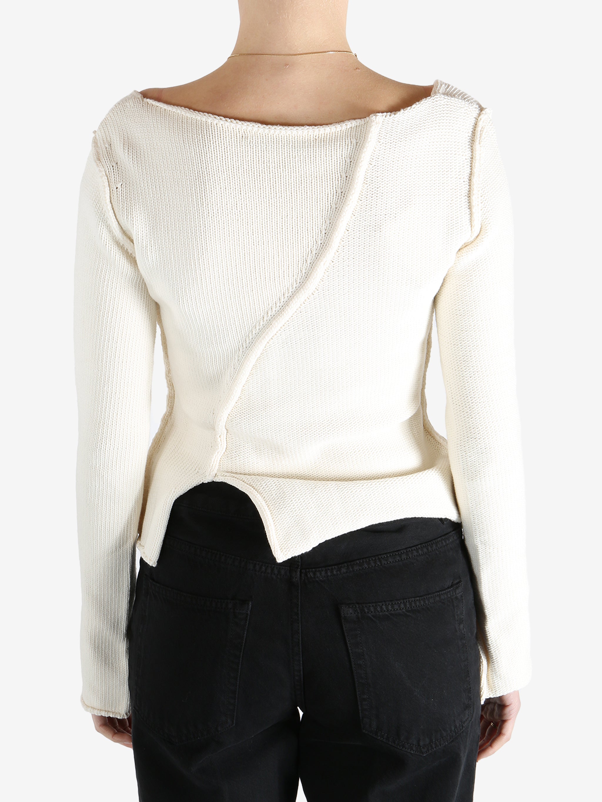 White sweater worn by a person, showing the sweater's fit
