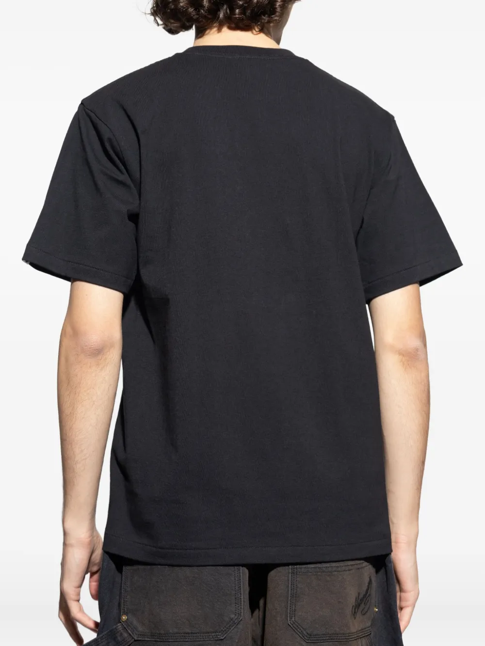 Black t-shirt worn by a person, showing the shirt's fit