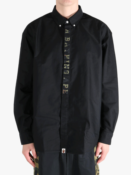 Black shirt worn by a person, showing the shirt's fit