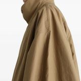 Close up of tan jacket, showing texture of the cotton fabric
