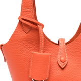 Close up of orange bag, showing texture of the calf leather fabric
