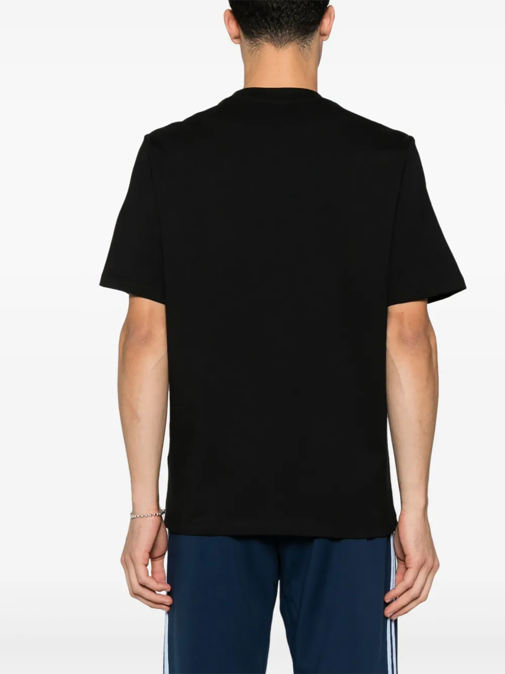 Black t-shirts worn by a person, showing the shirt's fit