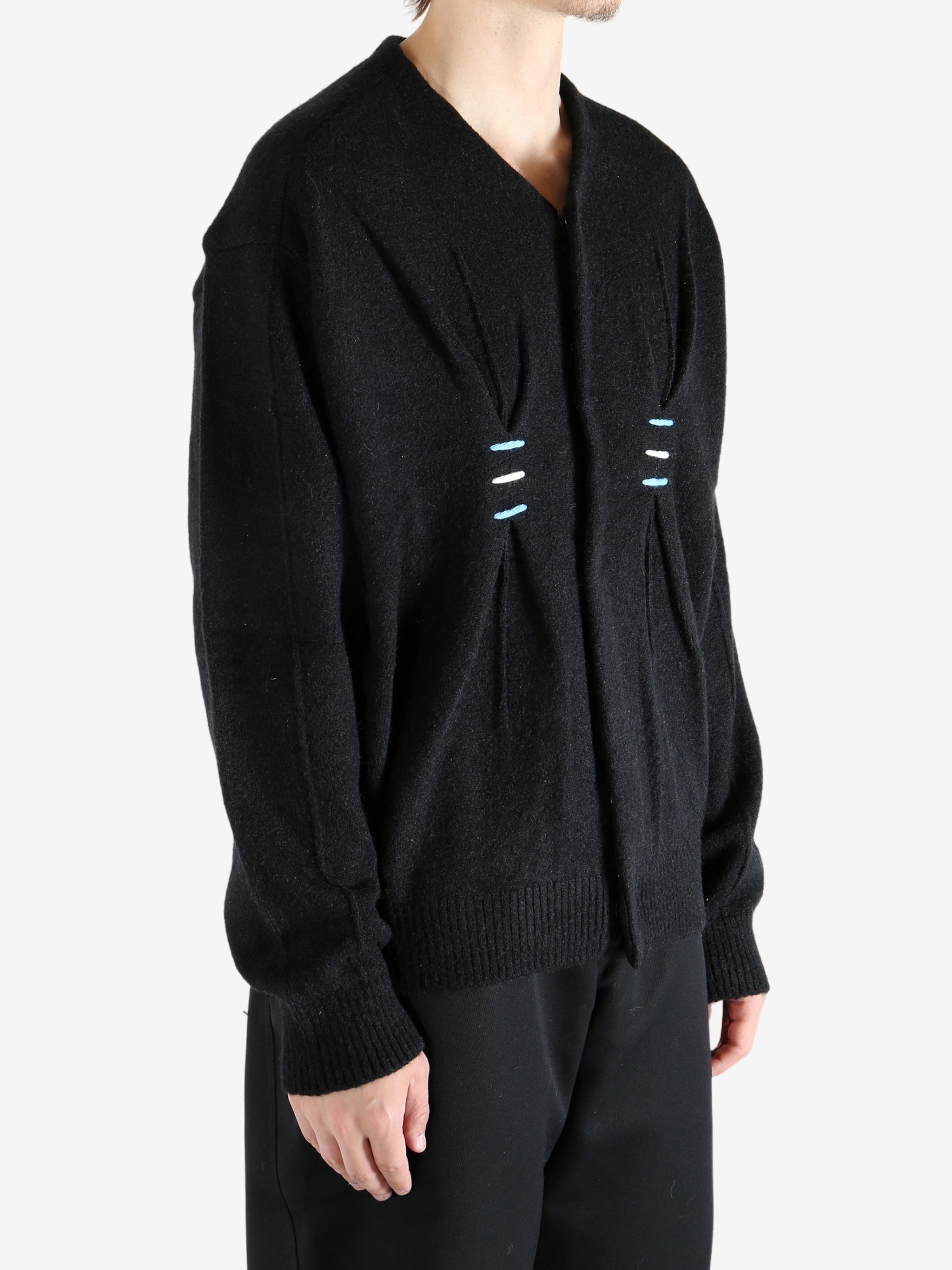 Black sweater worn by a person, showing the sweater's fit