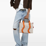 Tan bag worn by a person, showing the bag's fit