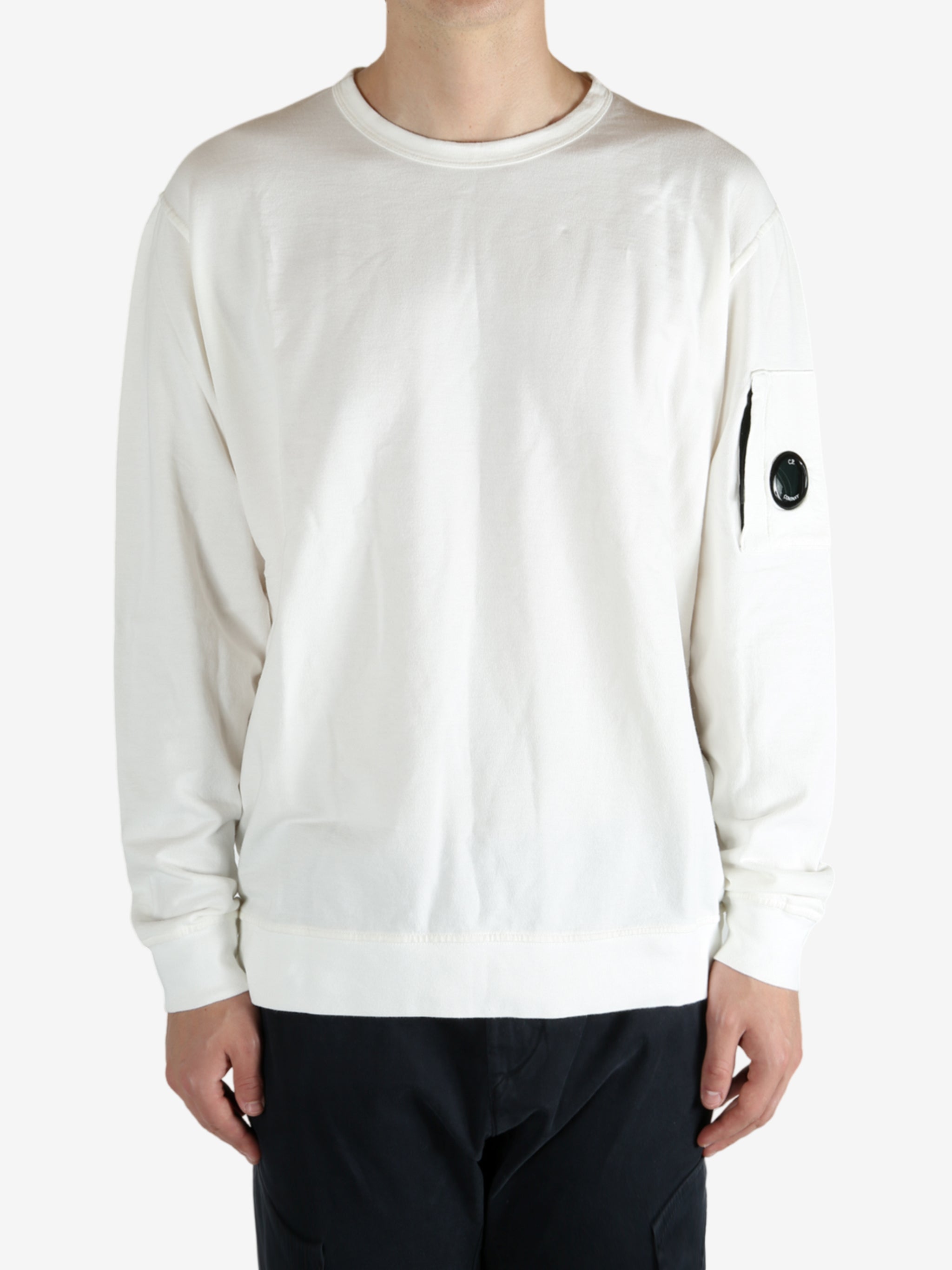White crewneck worn by a person, showing the crewneck fit