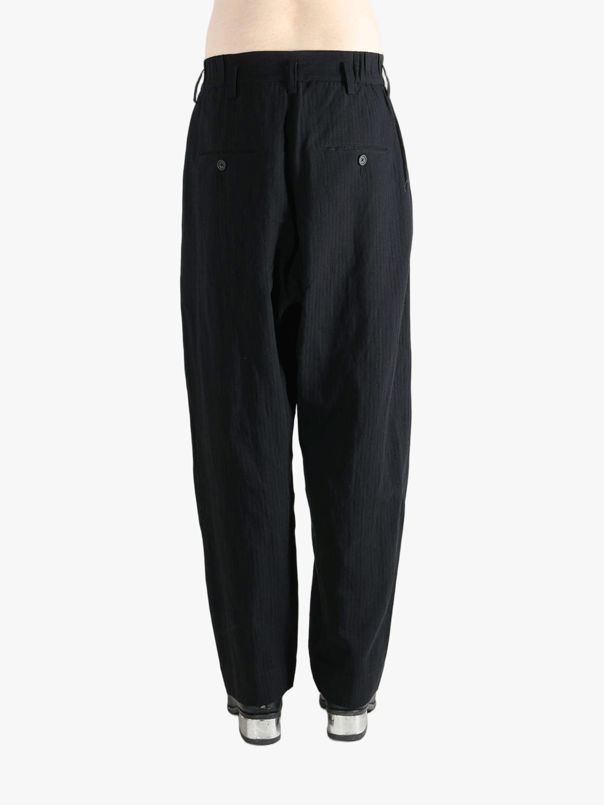 Black pants worn by a person, showing the pants fit