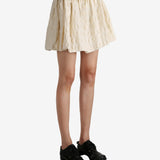 White skirt worn by a person, showing the skirt fit