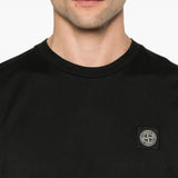 Close up of black t-shirts, showing texture of the cotton fabric