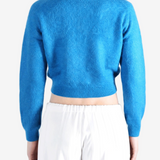 Blue knitwear worn by a person, showing the knitwear fit