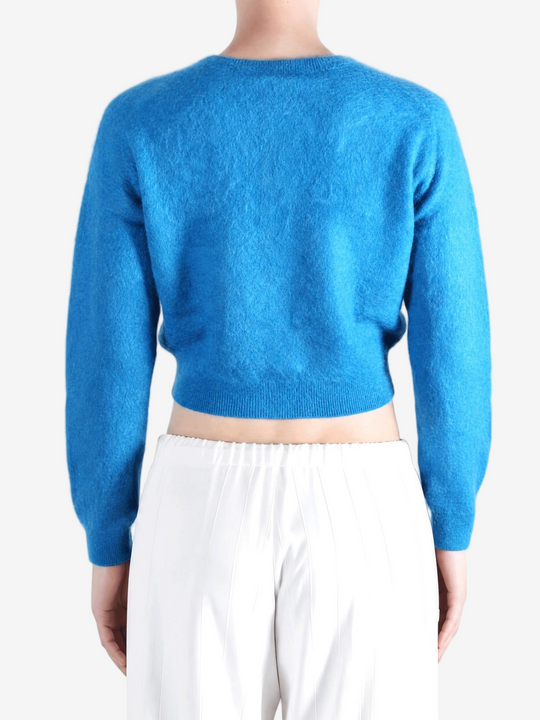 Blue knitwear worn by a person, showing the knitwear fit