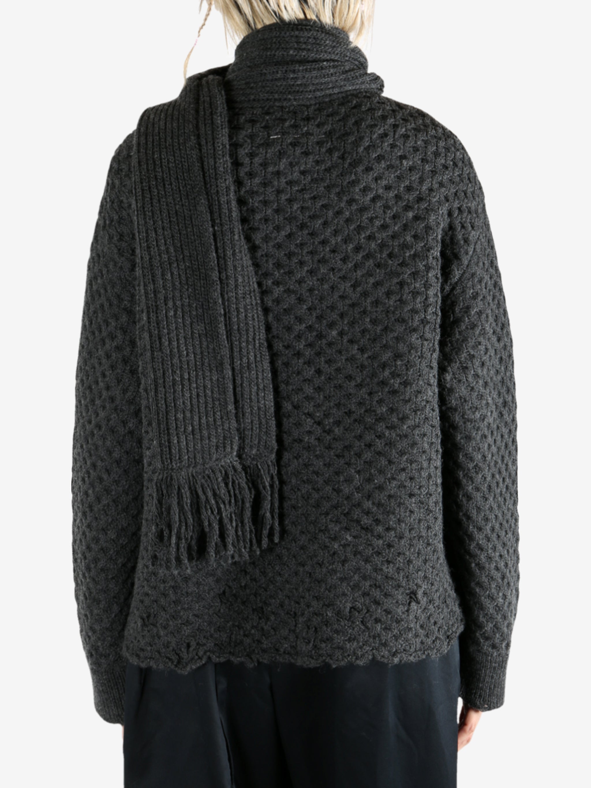Grey knitwear worn by a person, showing the knitwear fit