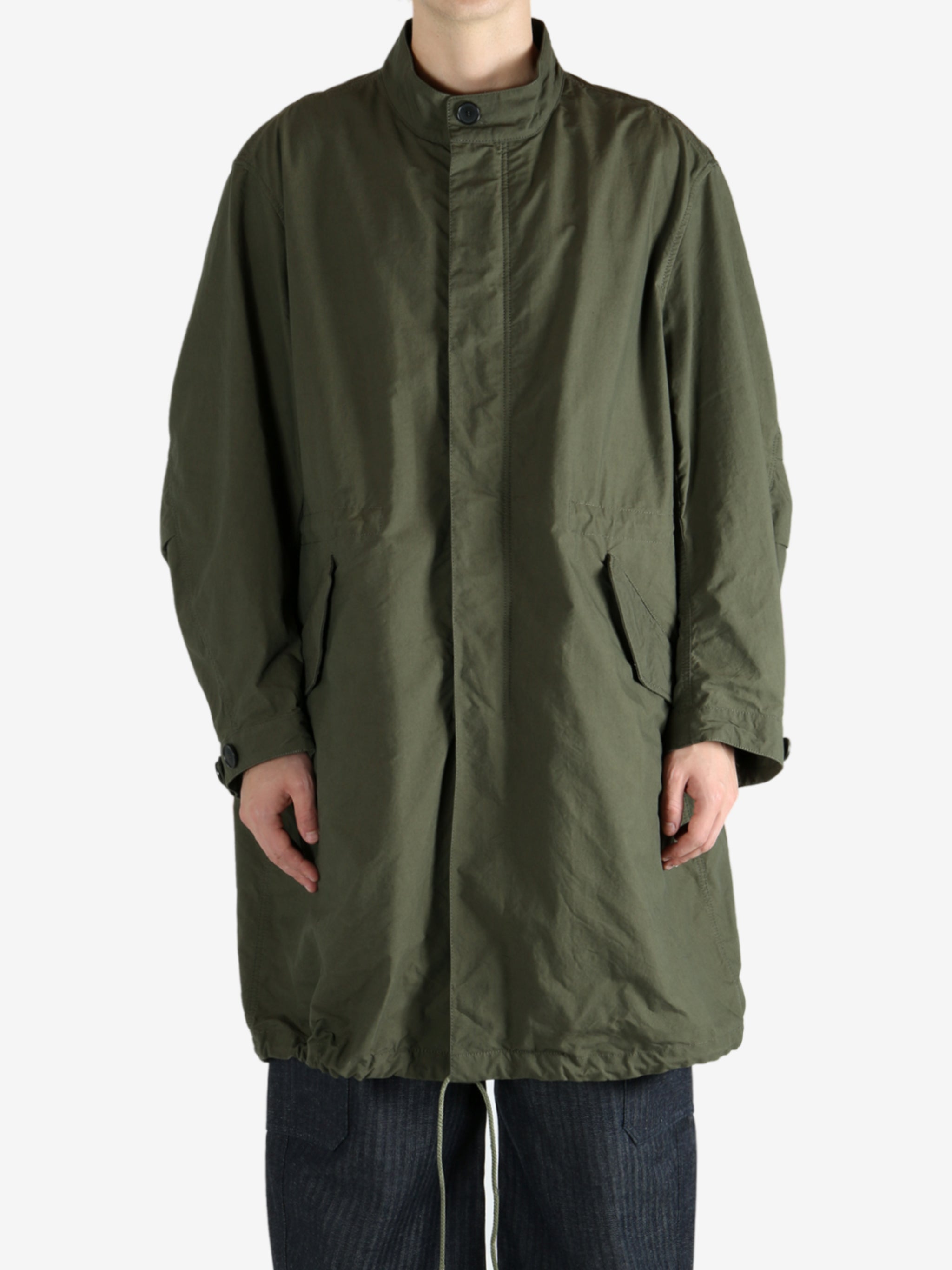 Green coat worn by a person, showing the coat fit