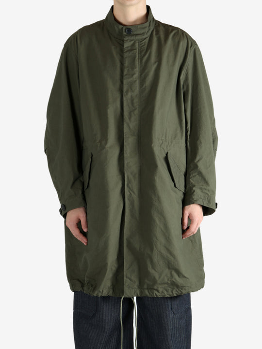 Green coat worn by a person, showing the coat fit