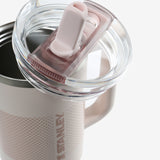 Close up of pink tumbler, showing texture of the clear lid and straw